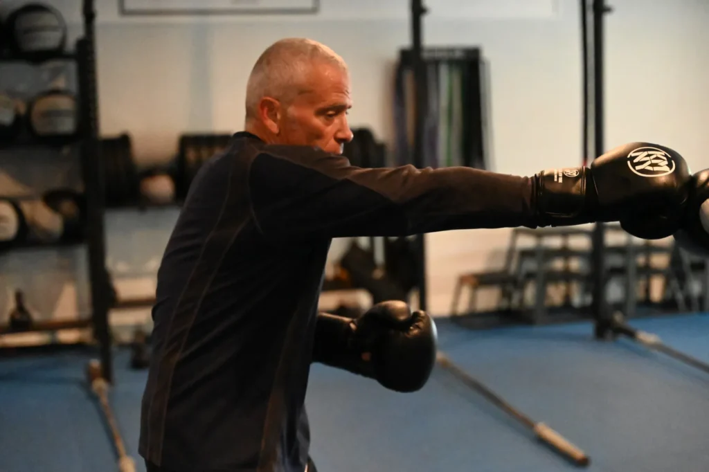 Adult Muay Thai student building upper body strength and technique through striking drills.